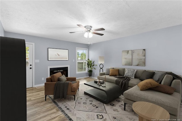 1591 Hazelcrest Dr, Fayetteville, NC 28304 - living room featuring light wood-style floors, ceiling fan, a textured ceiling, and a fireplace