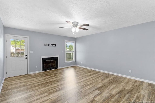 1591 Hazelcrest Dr, Fayetteville, NC 28304 - unfurnished living room featuring wood finished floors, a textured ceiling, a fireplace, and a ceiling fan