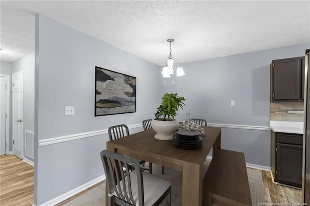 1591 Hazelcrest Dr, Fayetteville, NC 28304 - dining space featuring light wood-type flooring, a textured ceiling, and a chandelier