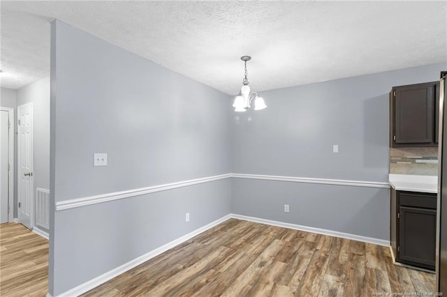 1591 Hazelcrest Dr, Fayetteville, NC 28304 - unfurnished dining area featuring wood finished floors, a textured ceiling, and a chandelier
