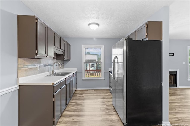 1591 Hazelcrest Dr, Fayetteville, NC 28304 - kitchen with stainless steel fridge, light wood finished floors, light countertops, a textured ceiling, and dark brown cabinets