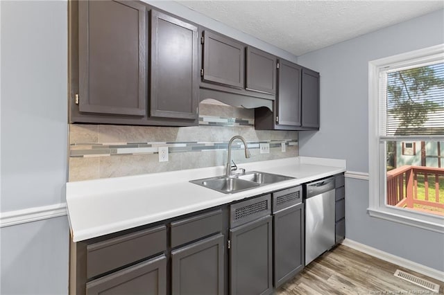 1591 Hazelcrest Dr, Fayetteville, NC 28304 - kitchen with stainless steel dishwasher, plenty of natural light, tasteful backsplash, light wood-type flooring, and a textured ceiling