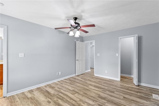 1591 Hazelcrest Dr, Fayetteville, NC 28304 - unfurnished bedroom featuring light wood-type flooring, a spacious closet, ensuite bathroom, and ceiling fan