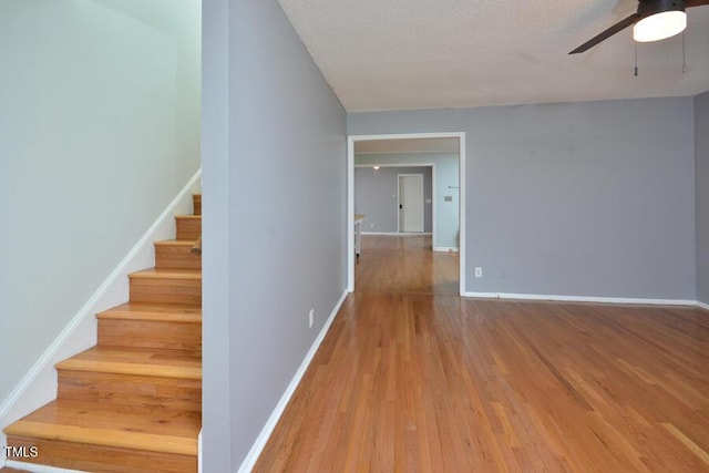 3300 Shaftsbury Drive St, Durham, NC 27704 - stairway with a ceiling fan, wood finished floors, and a textured ceiling