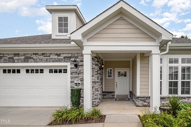 1164 Hudson Dr, Mebane, NC 27302 - property entrance featuring stone siding, a shingled roof, concrete driveway, and an attached garage