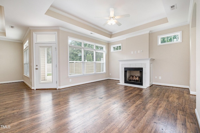 1164 Hudson Dr, Mebane, NC 27302 - unfurnished living room with a raised ceiling, a tile fireplace, plenty of natural light, dark wood-style floors, and crown molding