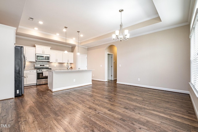1164 Hudson Dr, Mebane, NC 27302 - kitchen featuring stainless steel appliances, arched walkways, a raised ceiling, decorative backsplash, and ornamental molding