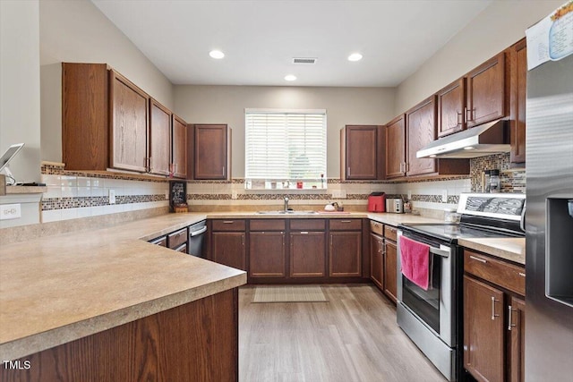 1742 Whirlaway Ct, Cary, NC 27519 - kitchen with stainless steel appliances, under cabinet range hood, light countertops, light wood finished floors, and recessed lighting