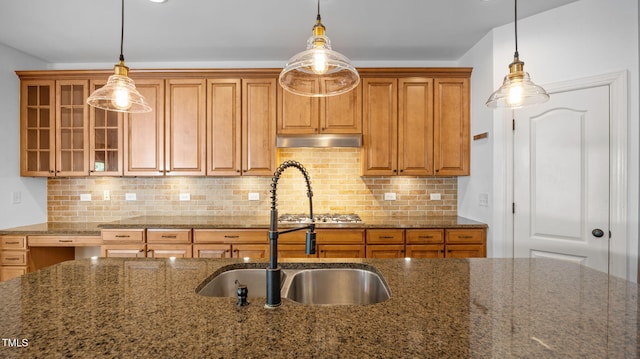 1019 Falkirk Dr, Burlington, NC 27215 - kitchen with brown cabinetry, dark stone countertops, glass insert cabinets, and hanging light fixtures