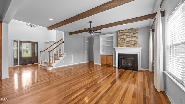 1019 Falkirk Dr, Burlington, NC 27215 - unfurnished living room featuring stairs, a fireplace, wood finished floors, beamed ceiling, and a ceiling fan