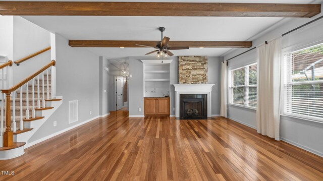 1019 Falkirk Dr, Burlington, NC 27215 - unfurnished living room with wood finished floors, plenty of natural light, a ceiling fan, stairway, and beam ceiling