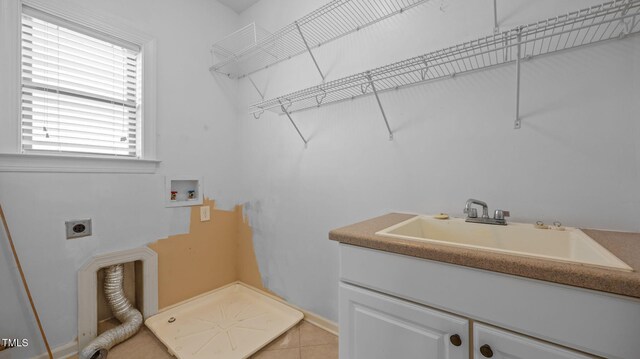 1019 Falkirk Dr, Burlington, NC 27215 - laundry area featuring hookup for an electric dryer, washer hookup, cabinet space, and light tile patterned flooring