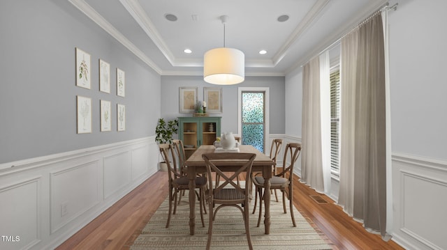 1019 Falkirk Dr, Burlington, NC 27215 - dining room with wood finished floors, a decorative wall, wainscoting, crown molding, and a raised ceiling