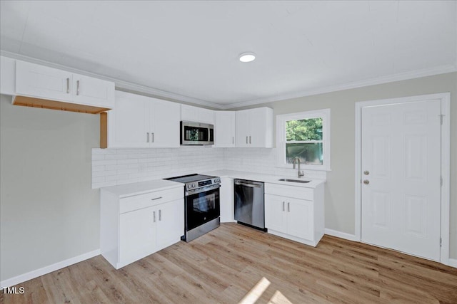 1109 Magnolia Dr, Durham, NC 27707 - kitchen featuring stainless steel appliances, light countertops, white cabinetry, tasteful backsplash, and crown molding