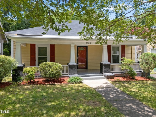 1309 Watts St, Durham, NC 27701 - view of front of home with covered porch, a front yard, and a shingled roof