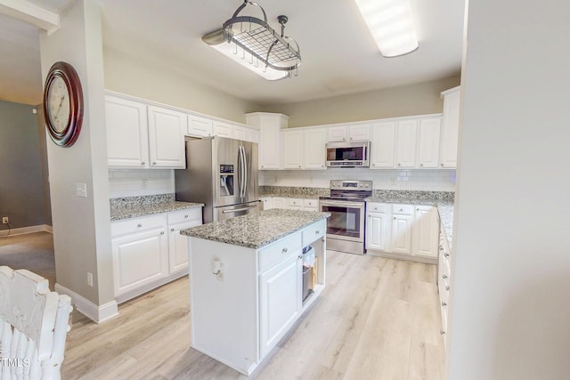 125 Al Gray Rd, Timberlake, NC 27583 - kitchen featuring appliances with stainless steel finishes, backsplash, a center island, and white cabinetry