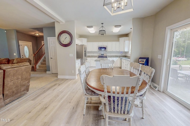 125 Al Gray Rd, Timberlake, NC 27583 - dining space with light wood finished floors, a chandelier, and stairs