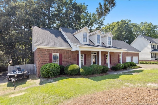 8017 Trout Creek Rd, Fayetteville, NC 28304 - cape cod-style house featuring brick siding, a garage, a porch, concrete driveway, and a shingled roof