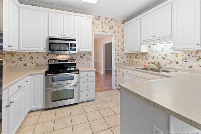 8017 Trout Creek Rd, Fayetteville, NC 28304 - kitchen featuring appliances with stainless steel finishes, wallpapered walls, light tile patterned flooring, white cabinets, and light countertops