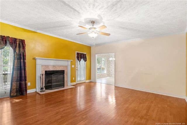 8017 Trout Creek Rd, Fayetteville, NC 28304 - unfurnished living room featuring a ceiling fan, wood finished floors, ornamental molding, a tile fireplace, and a textured ceiling
