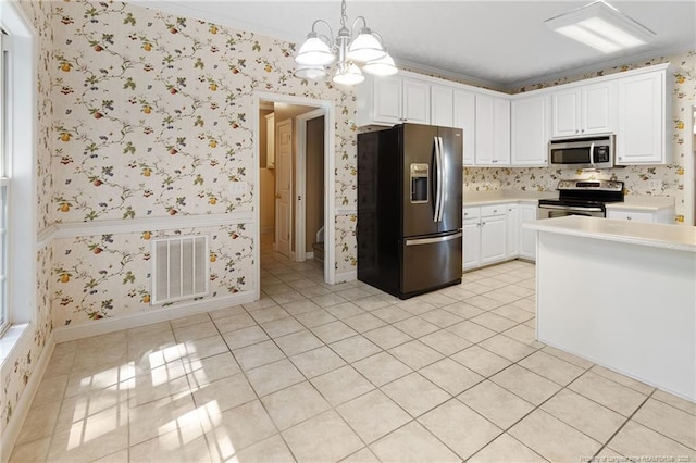 8017 Trout Creek Rd, Fayetteville, NC 28304 - kitchen featuring appliances with stainless steel finishes, a chandelier, light countertops, wallpapered walls, and light tile patterned floors