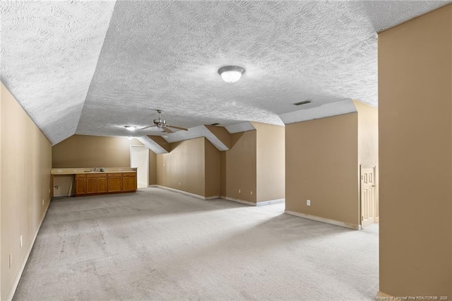 8017 Trout Creek Rd, Fayetteville, NC 28304 - additional living space featuring light colored carpet, vaulted ceiling, ceiling fan, and a textured ceiling