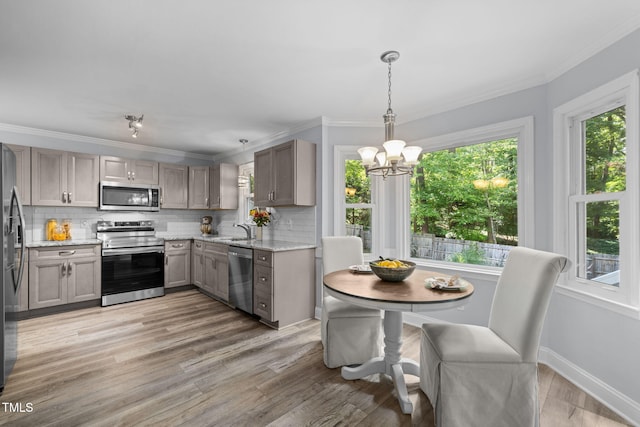 103 Wyseferry Ct, Morrisville, NC 27560 - kitchen featuring stainless steel appliances, a chandelier, healthy amount of natural light, and crown molding