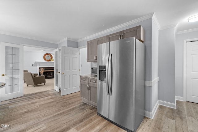 103 Wyseferry Ct, Morrisville, NC 27560 - kitchen featuring stainless steel fridge, light wood-style flooring, crown molding, a fireplace, and light countertops