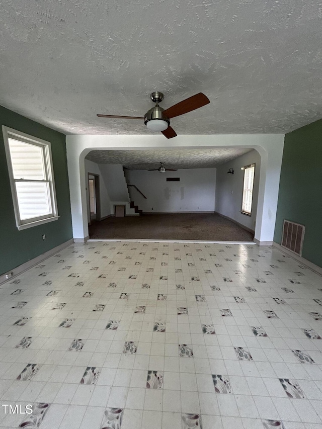 243 Victor Chandler Rd, Timberlake, NC 27583 - unfurnished living room featuring a textured ceiling, ceiling fan, and arched walkways