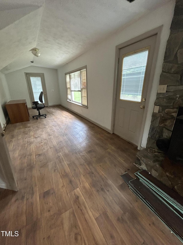 243 Victor Chandler Rd, Timberlake, NC 27583 - unfurnished living room featuring hardwood / wood-style flooring, lofted ceiling, and a textured ceiling