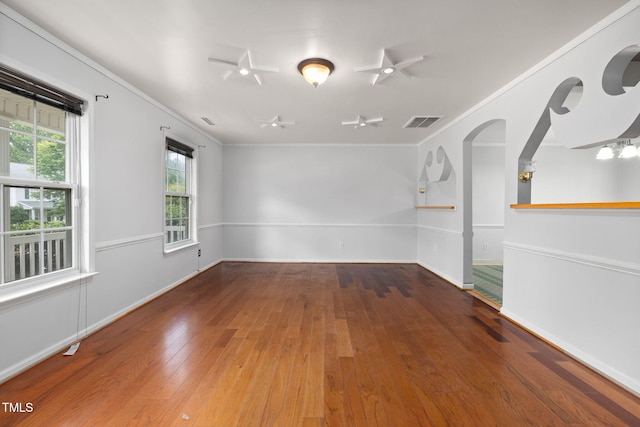 5528 Wilhagan Ct, Raleigh, NC 27616 - empty room featuring crown molding, wood-type flooring, a ceiling fan, and arched walkways