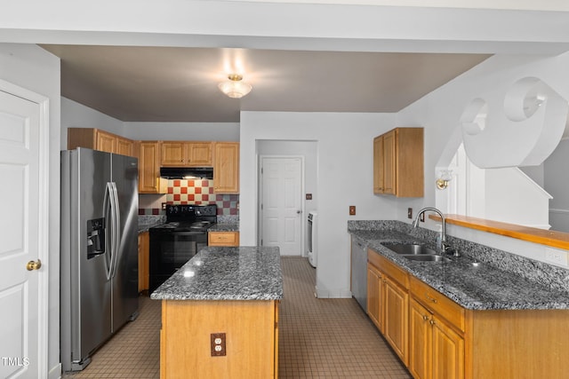 5528 Wilhagan Ct, Raleigh, NC 27616 - kitchen with stainless steel appliances, under cabinet range hood, a kitchen island, dark stone counters, and light tile patterned floors