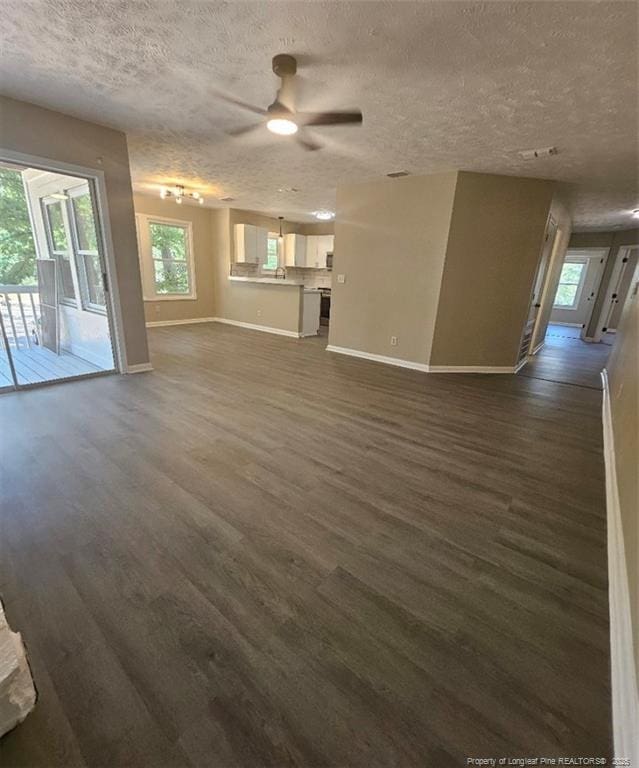 6771 Willowbrook Dr Unit 6, Fayetteville, NC 28314 - unfurnished living room with a textured ceiling, dark wood-type flooring, a ceiling fan, and healthy amount of natural light