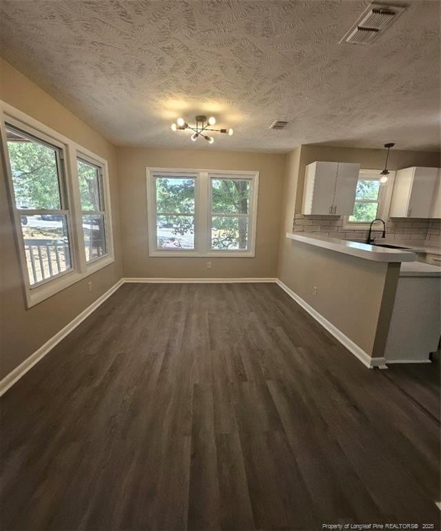 6771 Willowbrook Dr Unit 6, Fayetteville, NC 28314 - unfurnished dining area with a textured ceiling and dark wood-style floors