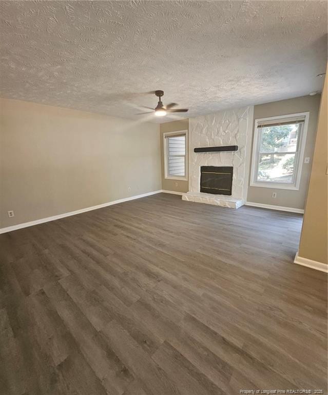6771 Willowbrook Dr Unit 6, Fayetteville, NC 28314 - unfurnished living room with a textured ceiling, ceiling fan, dark wood-style floors, healthy amount of natural light, and a fireplace