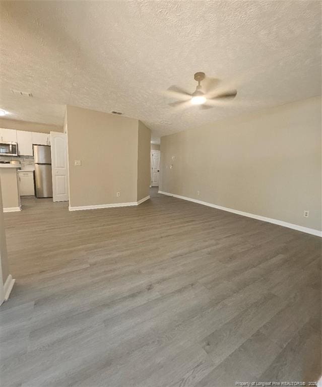 6771 Willowbrook Dr Unit 6, Fayetteville, NC 28314 - unfurnished living room with a textured ceiling, ceiling fan, and wood finished floors