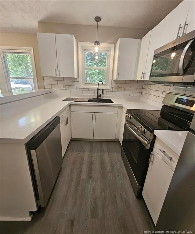 6771 Willowbrook Dr Unit 6, Fayetteville, NC 28314 - kitchen featuring stainless steel appliances, dark wood-style flooring, plenty of natural light, tasteful backsplash, and a textured ceiling