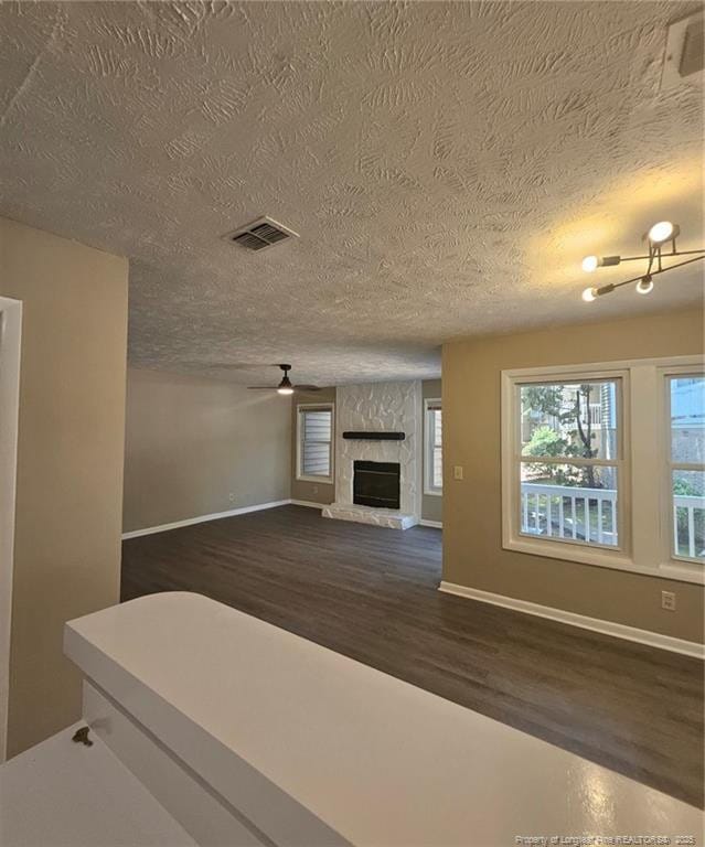 6771 Willowbrook Dr Unit 6, Fayetteville, NC 28314 - unfurnished living room with dark wood finished floors, a textured ceiling, and a stone fireplace