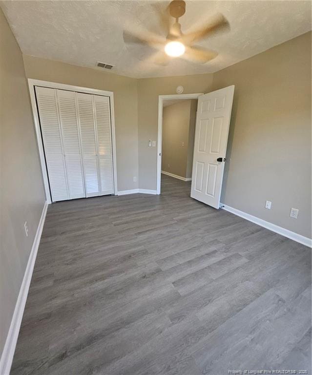 6771 Willowbrook Dr Unit 6, Fayetteville, NC 28314 - unfurnished bedroom with dark wood-type flooring, a closet, and a ceiling fan