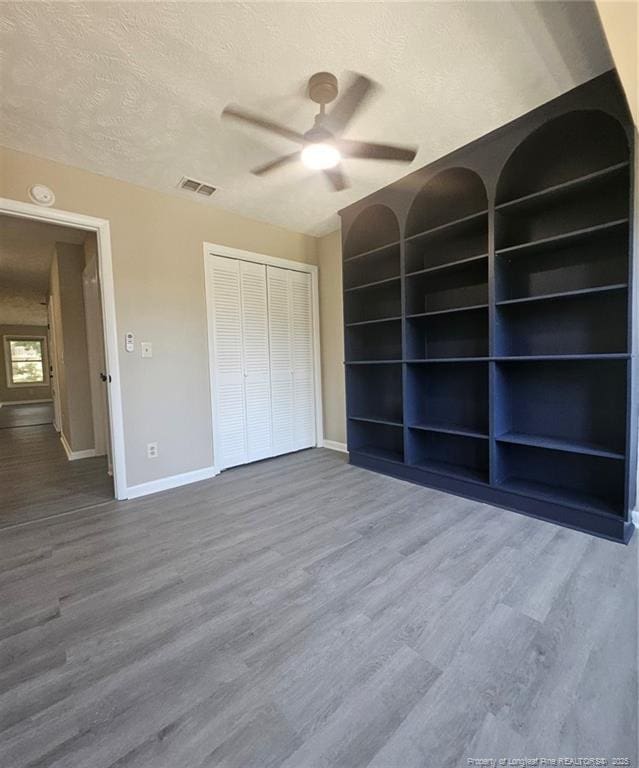 6771 Willowbrook Dr Unit 6, Fayetteville, NC 28314 - unfurnished bedroom featuring a textured ceiling, wood finished floors, a closet, and a ceiling fan