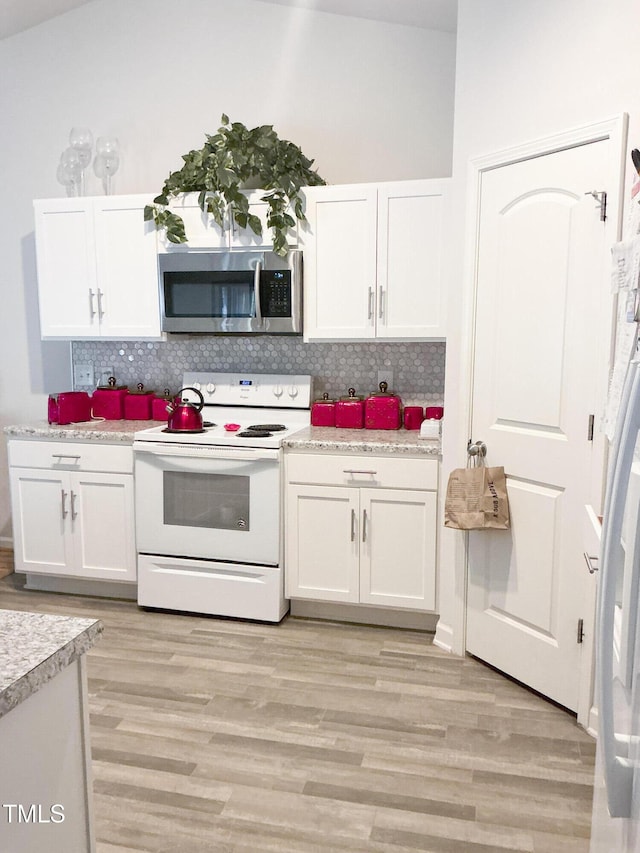 1008 Gold Cir, Mebane, NC 27302 - kitchen featuring stainless steel microwave, electric stove, white cabinetry, light wood-style flooring, and decorative backsplash