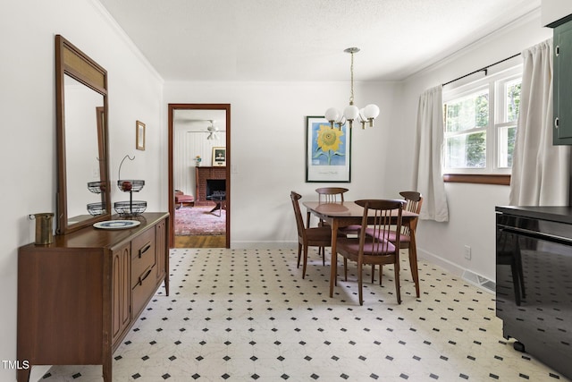 2603 Fairlawn Rd, Durham, NC 27705 - dining room with a chandelier, crown molding, a brick fireplace, and light flooring