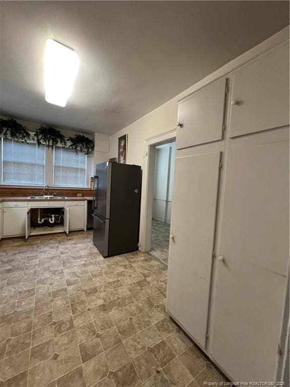 206 E 10th St, Lumberton, NC 28358 - kitchen with freestanding refrigerator and white cabinetry