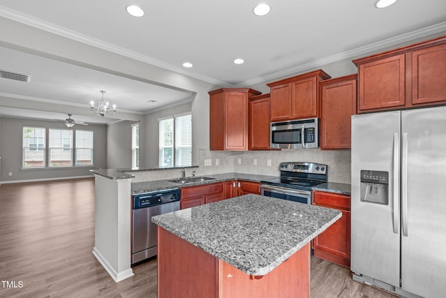 1014 Summerhouse Rd, Cary, NC 27519 - kitchen featuring appliances with stainless steel finishes, crown molding, dark stone counters, light wood-type flooring, and recessed lighting