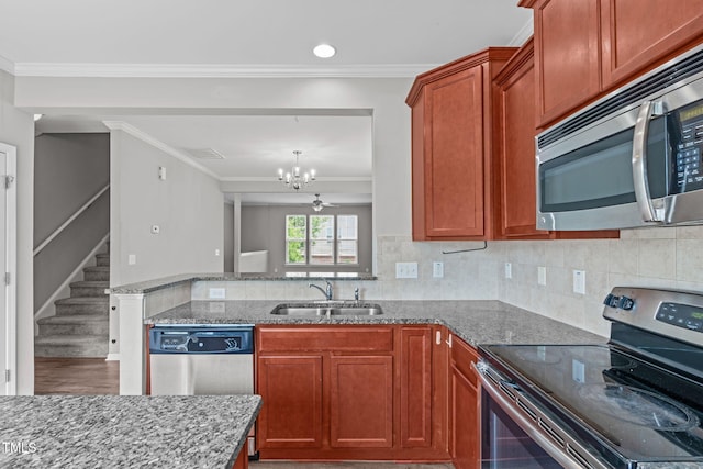 1014 Summerhouse Rd, Cary, NC 27519 - kitchen featuring appliances with stainless steel finishes, a chandelier, stone countertops, ornamental molding, and recessed lighting