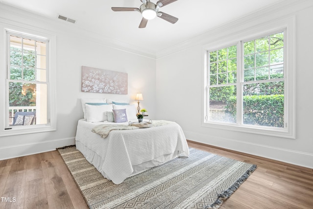 1310 Durlain Dr Unit 102, Raleigh, NC 27614 - bedroom featuring multiple windows, wood finished floors, ornamental molding, and ceiling fan