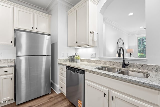 1310 Durlain Dr Unit 102, Raleigh, NC 27614 - kitchen with appliances with stainless steel finishes, crown molding, arched walkways, white cabinetry, and wood finished floors