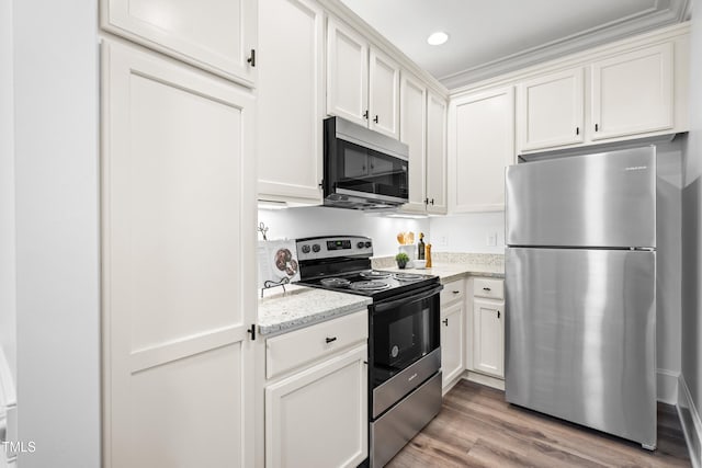 1310 Durlain Dr Unit 102, Raleigh, NC 27614 - kitchen with appliances with stainless steel finishes, white cabinetry, light wood-type flooring, light stone countertops, and recessed lighting