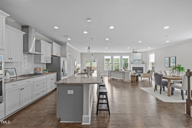 1017 Blackpool Ct, Apex, NC 27502 - kitchen with stainless steel appliances, wall chimney exhaust hood, recessed lighting, ornamental molding, and ceiling fan