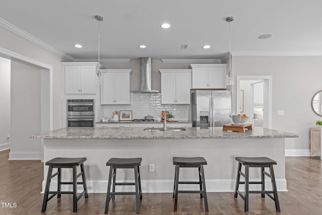1017 Blackpool Ct, Apex, NC 27502 - kitchen with appliances with stainless steel finishes, wall chimney range hood, a spacious island, crown molding, and tasteful backsplash